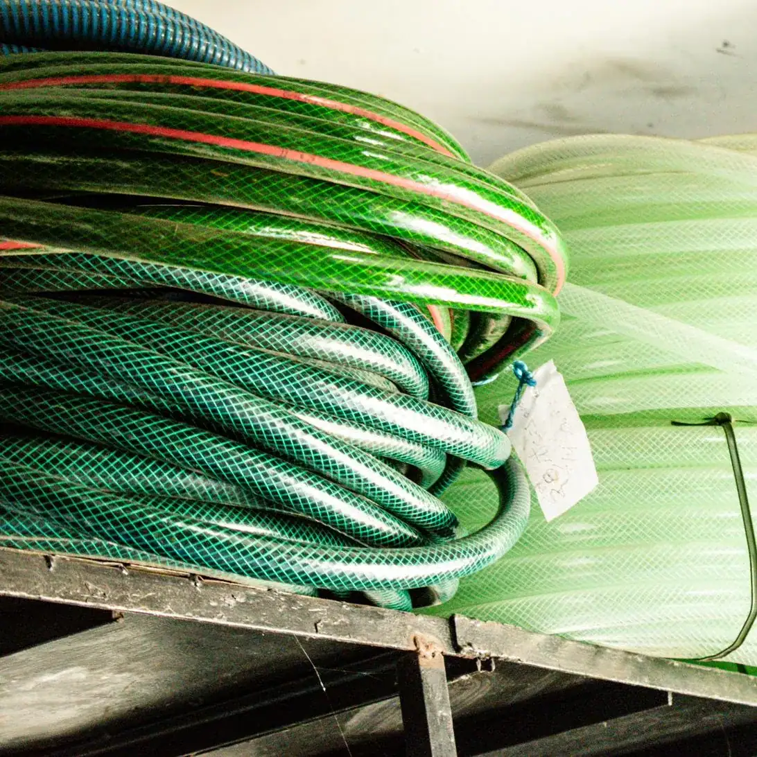 Rollos de manguera verde con refuerzo textil en inventario